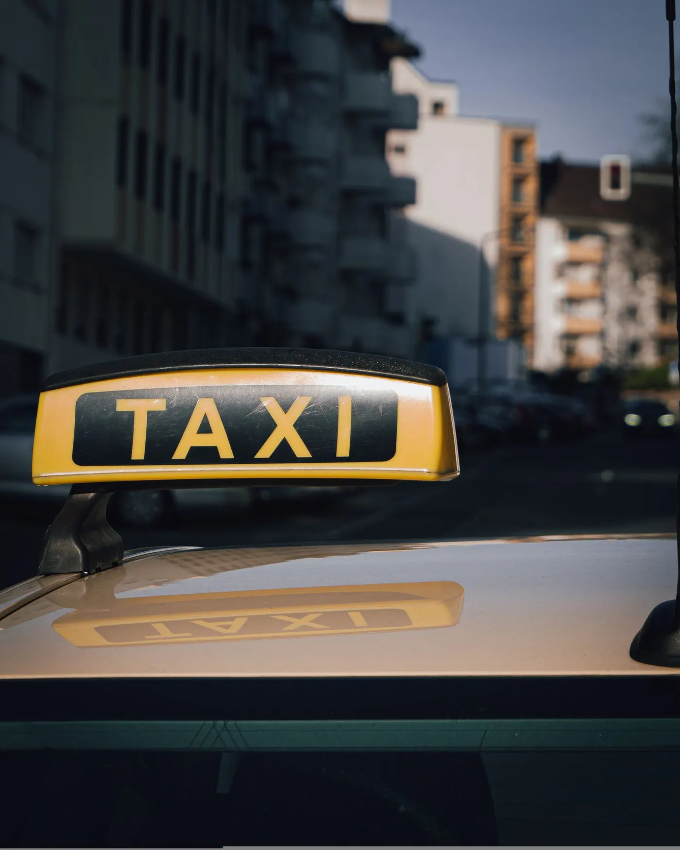 Taxiskylt på biltak i stadsmiljö